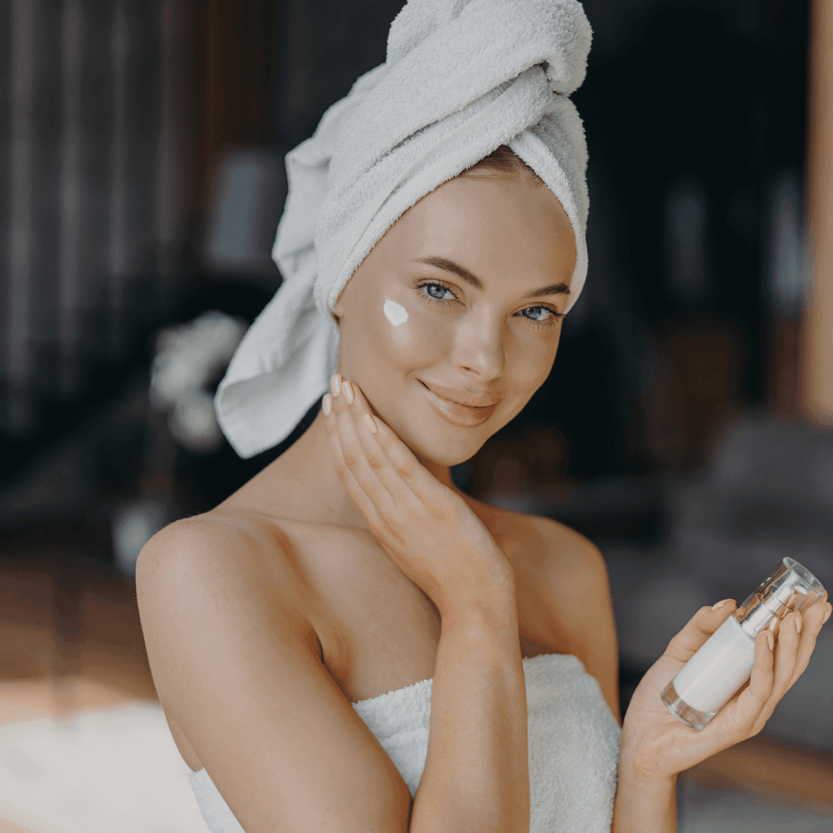 woman with glowing healthy skin applying face cream