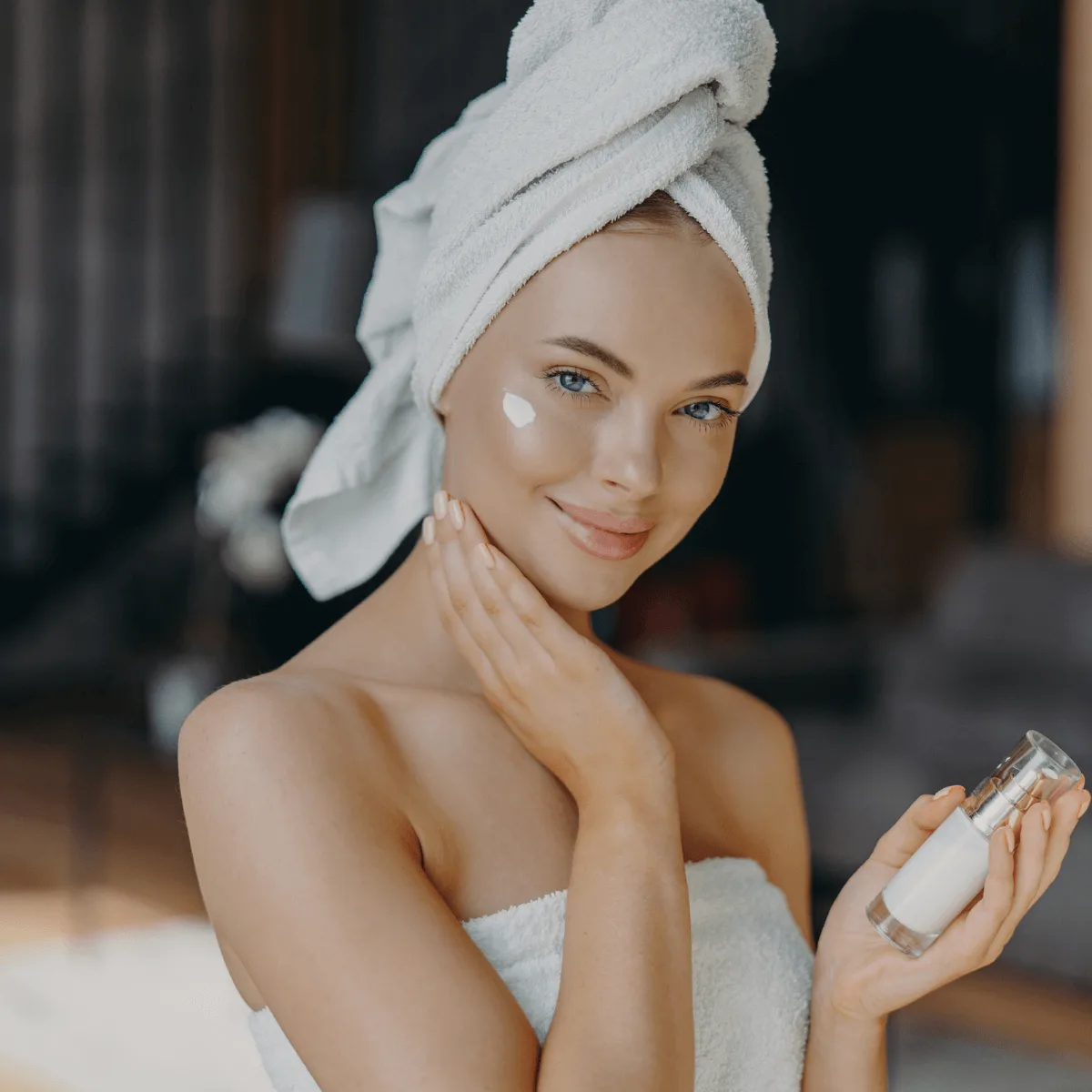 woman with glowing healthy skin applying face cream