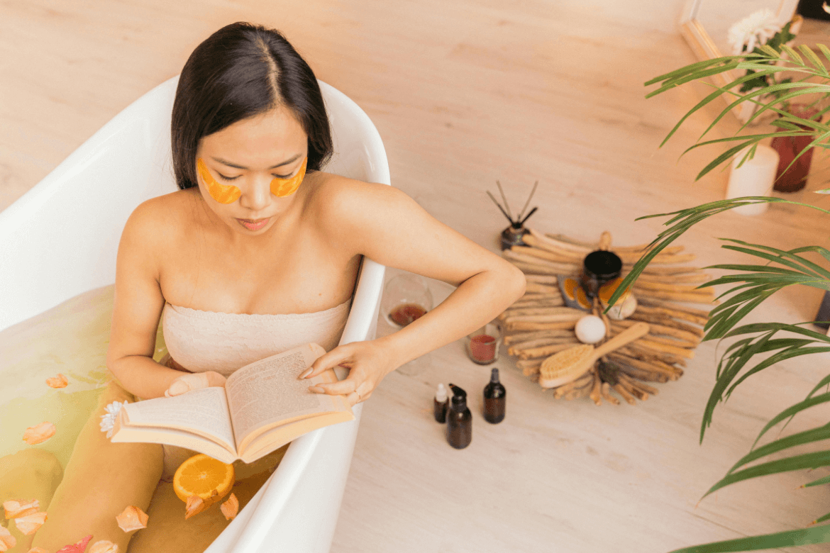 Woman relaxing in a body detox bathtub, reading.