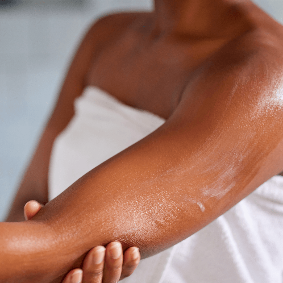woman applying hydrating lotion on her skin