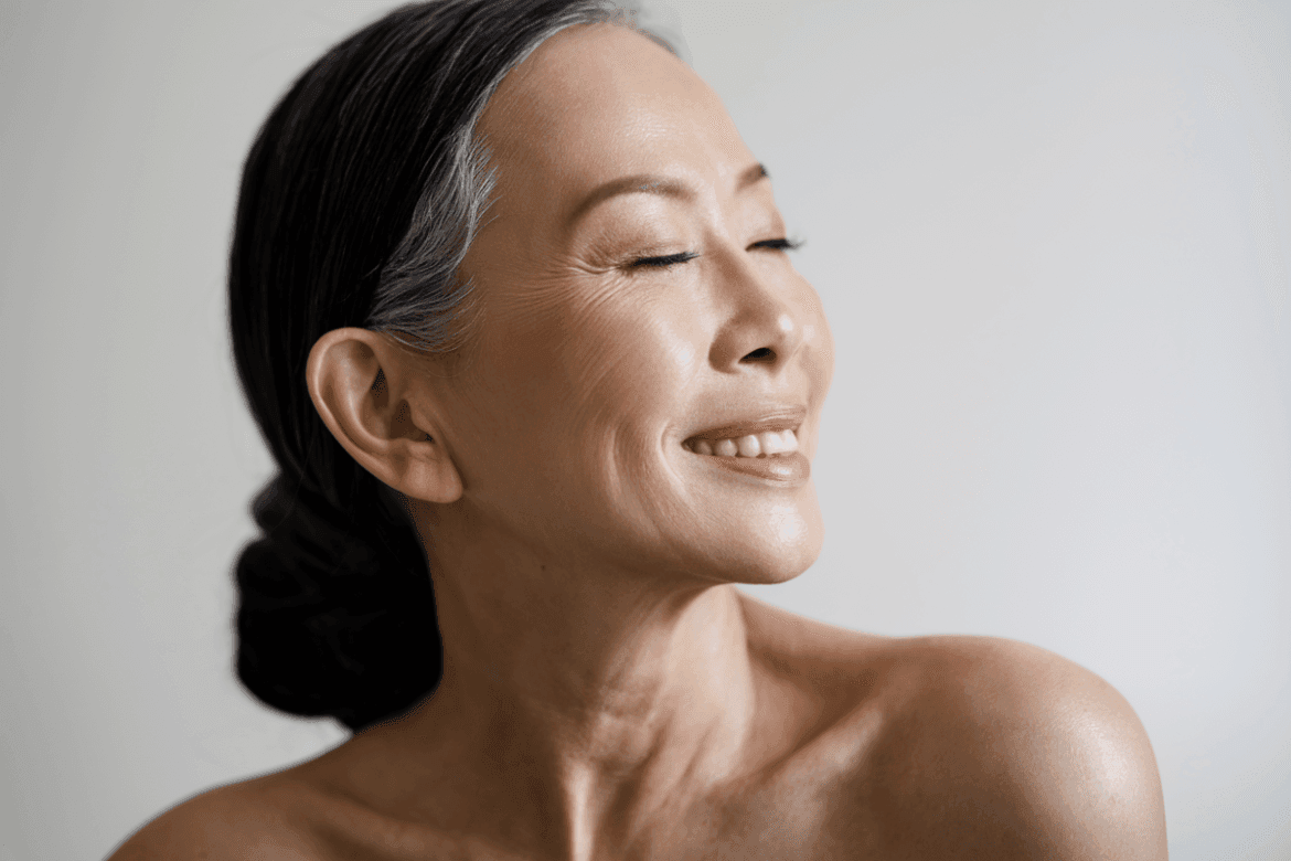 A radiant mature woman smiling with closed eyes.