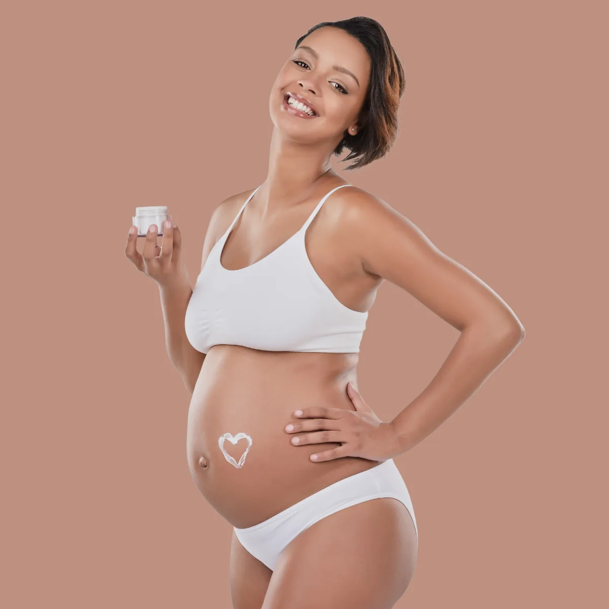 pregnant woman applying moisturizer on her skin